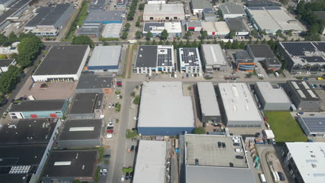 aerial-view-of-multiple-buildings-with-photovoltaic-solar-panels-on-rooftop-on-industrial-terrain