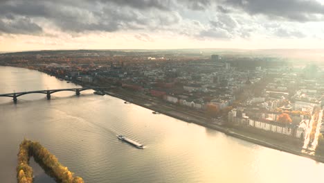 Golden-light-aerial-shot-of-Mainz-in-Germany-by-a-Drone-with-the-Dome-in-the-back-showing-the-city-of-Biontech-in-front-of-the-Rhine-river