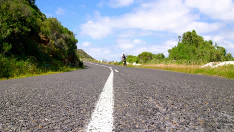 female cyclist cycling on a countryside road 4k