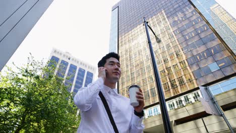 man having coffee while talking on mobile phone on street 4k