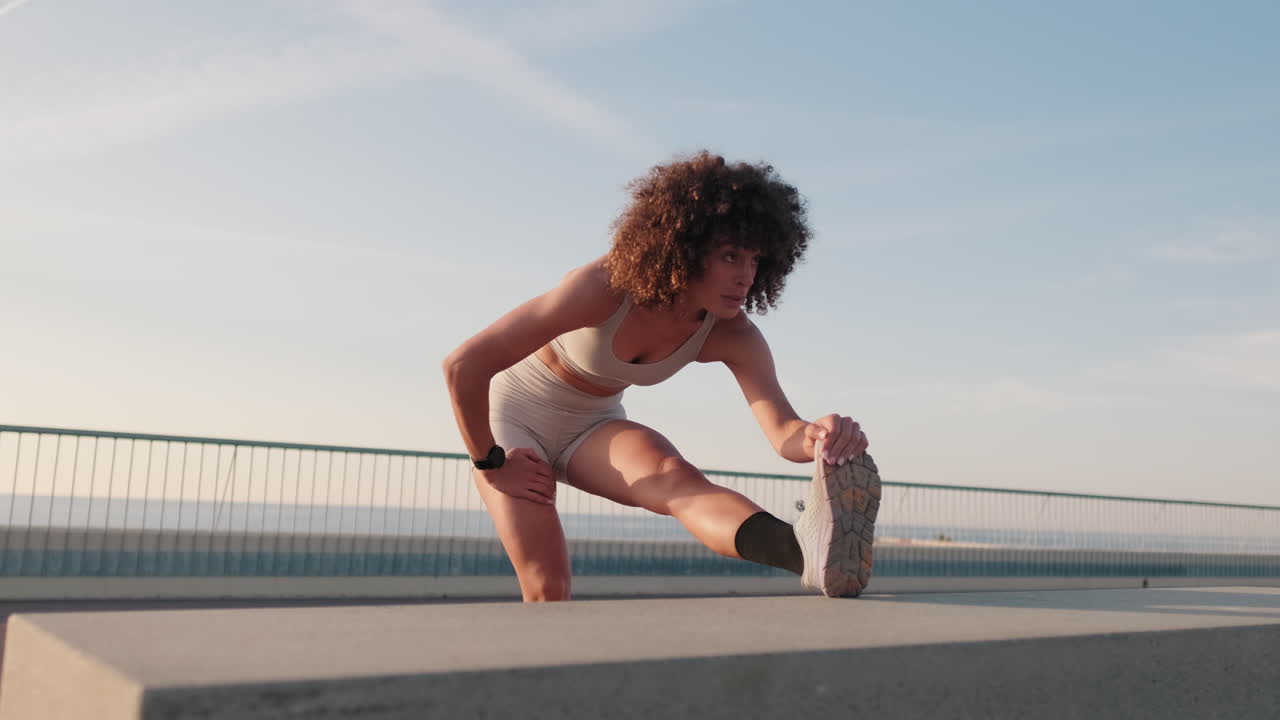 Young Woman Stretching near the Sea