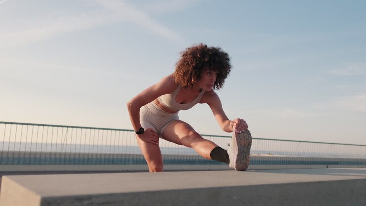 Young Woman Stretching near the Sea