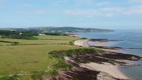 Traeth-Lligwy-Anglesey-island-coastal-seascape-aerial-view-descending-to-scenic-Welsh-weathered-coastline