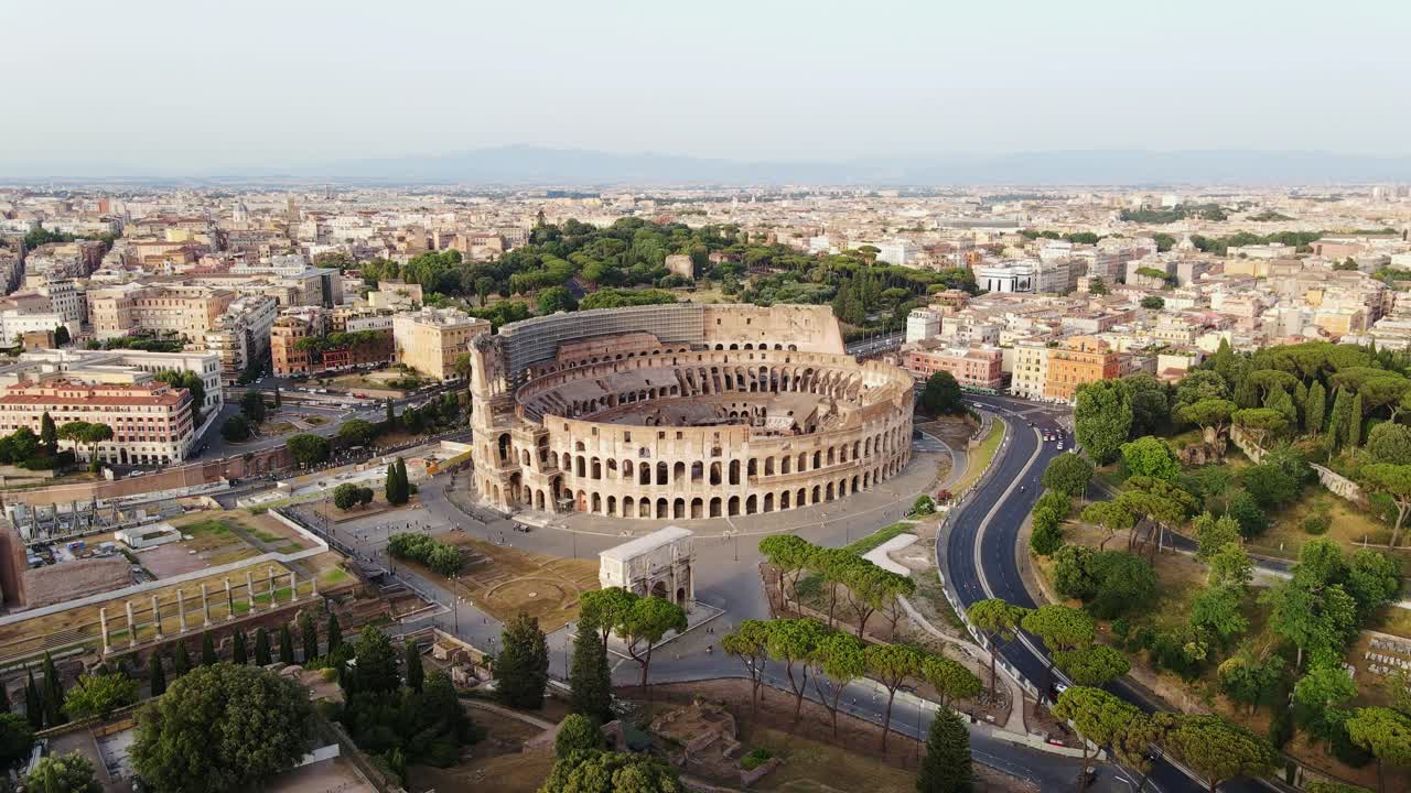 Ancient Roman Colosseum dominates Rome skyline during golden hour flight, Italy