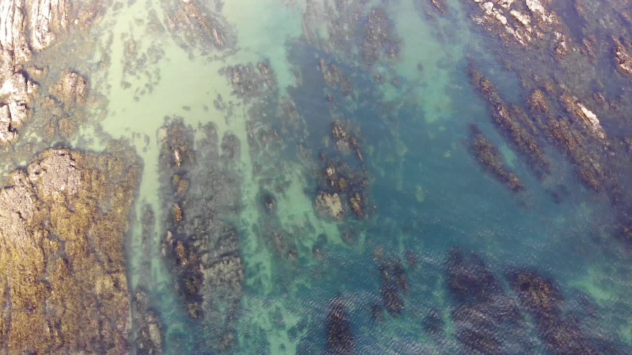 Aerial Birds Eye View Of Low Tide Showing Jurassic Rock Striations With Small Waves Coming In