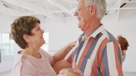 Caucasian-senior-couples-spending-time-together-in-a-ballroom-taking-part-in-dancing-class