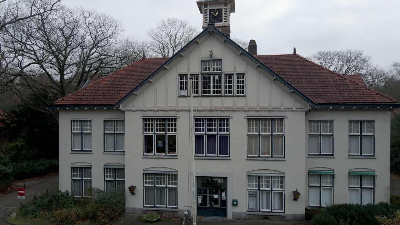 가을에 작은 마을을 감독하는 시계탑이 있는 오래된 저택의 지브