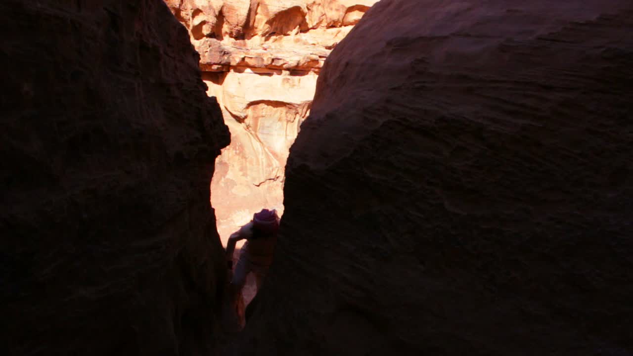 un hombre beduino sube a los acantilados en wadi rum jordan