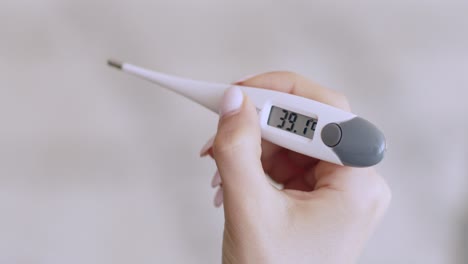 hand holding a digital thermometer