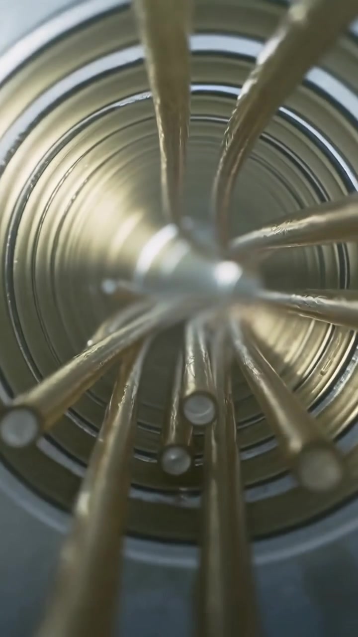 Vertical video: Advancing camera revealing brass rods approaching inside metal tube, with hub