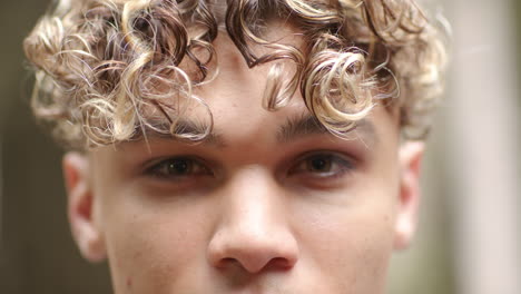 close-up of young man with curly hair gazing intently, capturing emotion