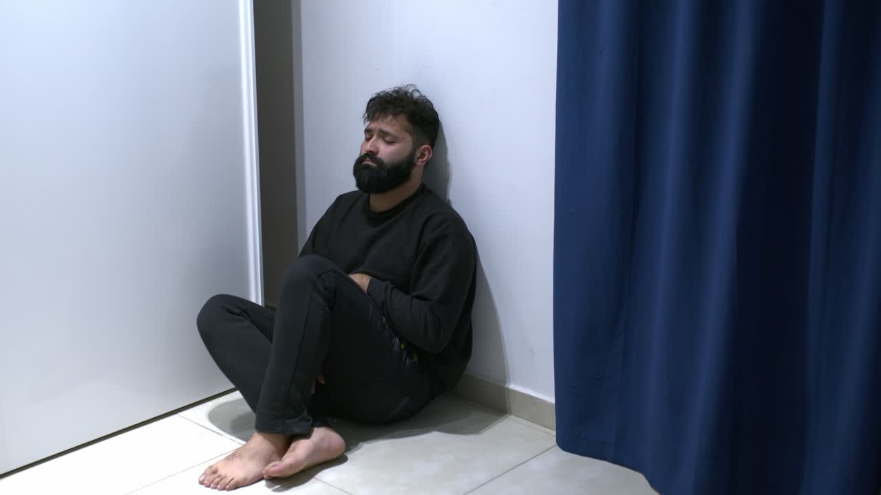 Man suffering psychotic episode alone looking at the mirror