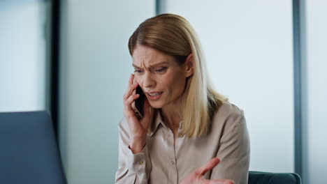 nervous manager shouting smartphone at work closeup. furious woman arguing call