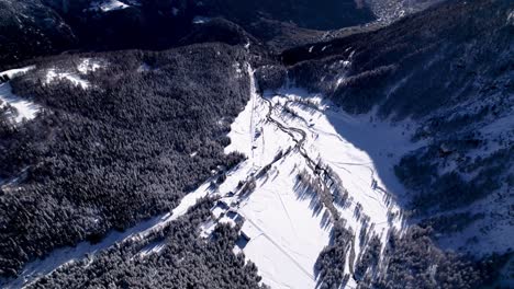 Aerial-view-of-snow-covered-landscape-with-forestsm-hills-and-rivers-on-a-sunny-winter-day-in-Alp-Grum,-Switzerland