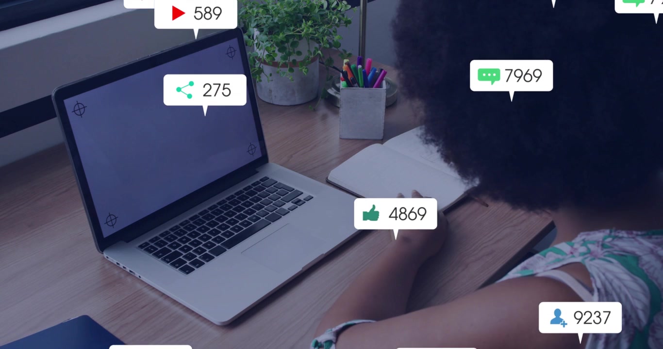 Woman creator monitoring laptop, alerts appearing as badges over screen, showing social media surge