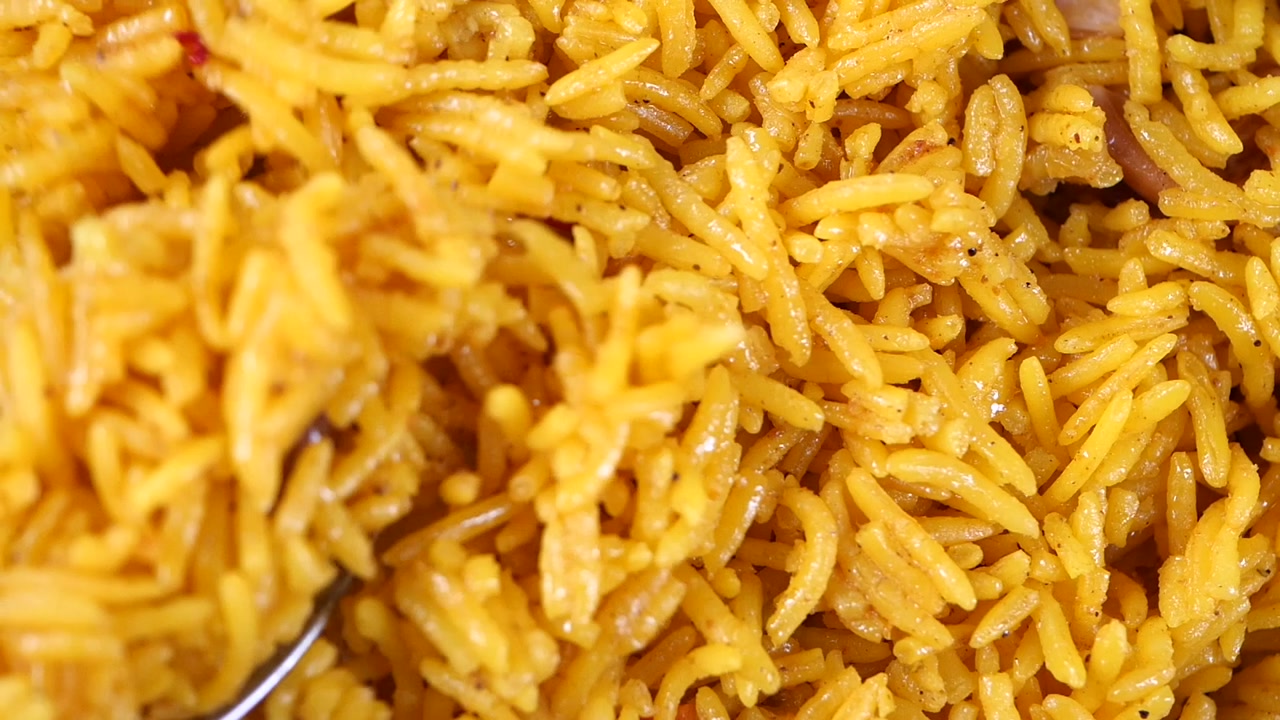 Close-Up of Yellow Rice Being Scooped with a Spoon