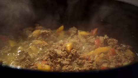 la carne molida, los pimientos y las cebollas se doran en el horno holandés