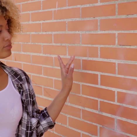 woman walking along a brick wall