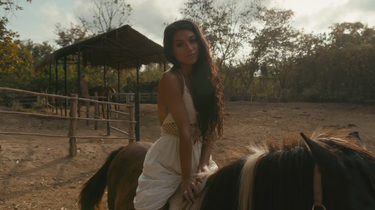 Young woman riding a horse in a rural outdoor setting