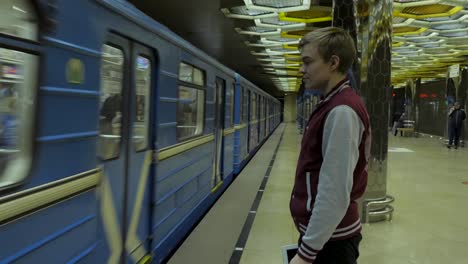 teenager waiting for subway train at station