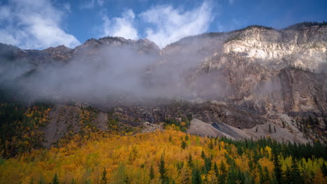 time lapse, autumn season in high mountains, yellow aspen forest in valley under peaks and clouds