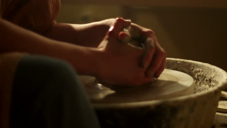 hands shaping clay on a pottery wheel
