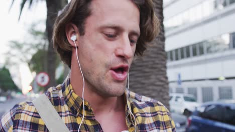 caucasian male talking and using his phone in a street