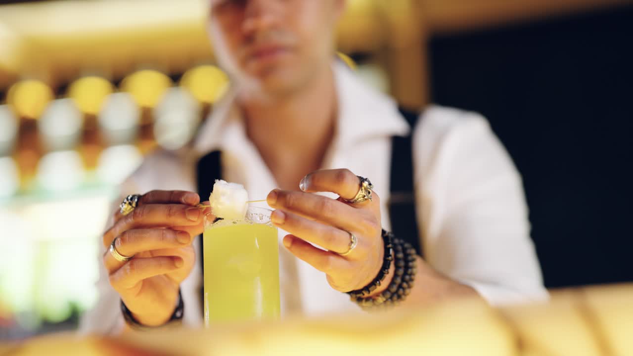 Bartender Garnishing a Green Cocktail with a Skewered Fruit