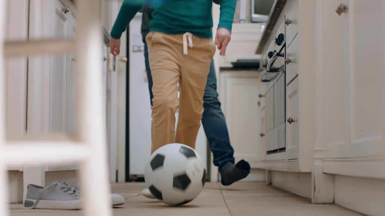 padre e hijo jugando al fútbol en la cocina pateando una pelota de fútbol niño disfrutando del juego con papá en casa