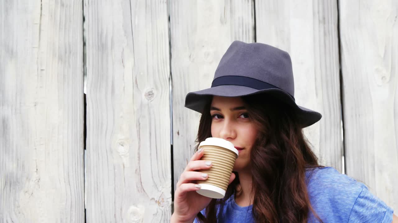 Beautiful woman in hat having coffee