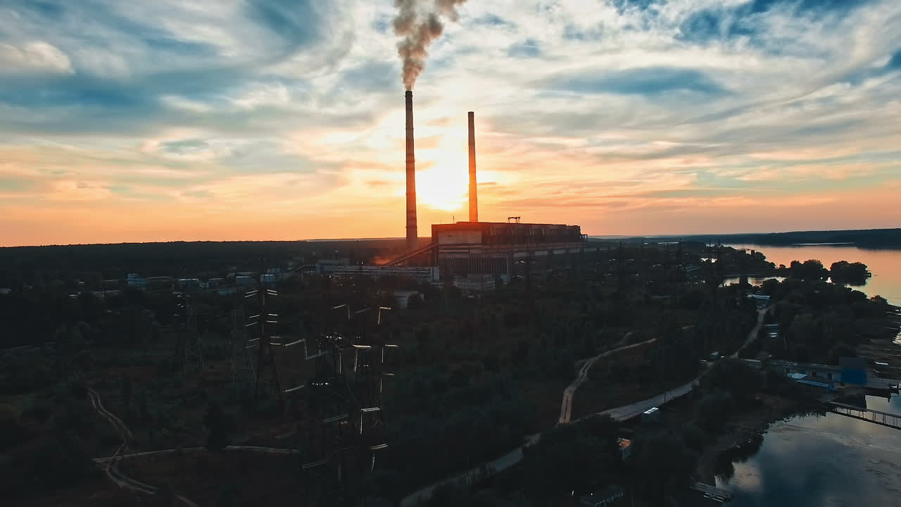 Tubo di fabbrica che inquina l'aria. Tubo di fabbrica che inquina l'aria al tramonto, problemi ambientali, fumo dalle ciminiere.