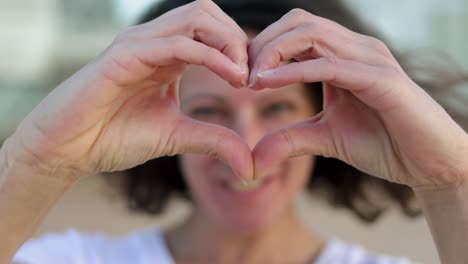 female hands making heart shape.