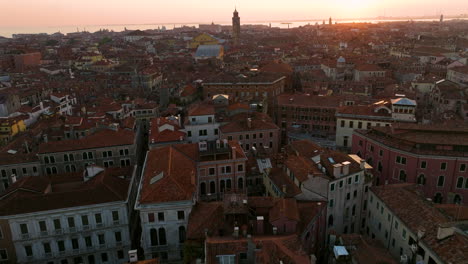 flying over old venitian roofs in venice, italy at sunset - aerial drone shot