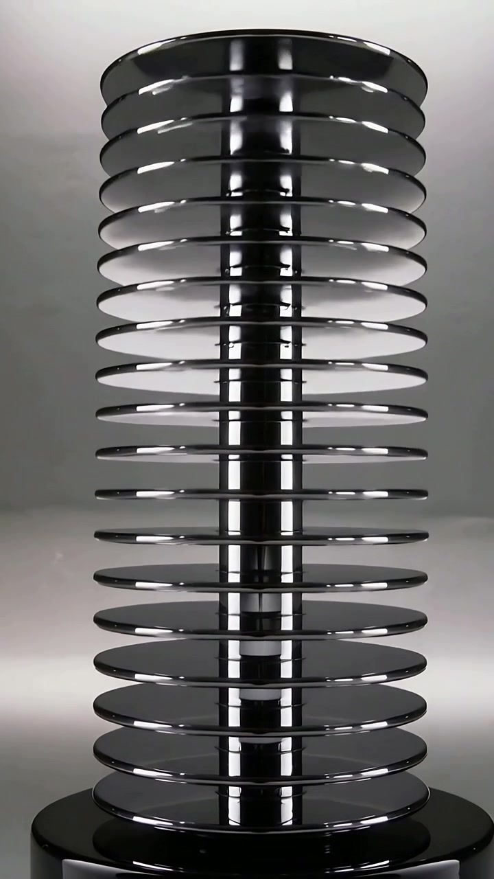 Vertical video: Pulling back camera to reveal metal post stacked with discs and base in studio set