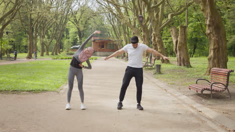 couple stretching in park