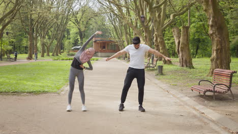 una pareja estirándose en un parque.