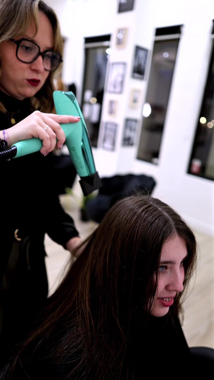Hairdresser Drying Client's Hair in a Modern Salon