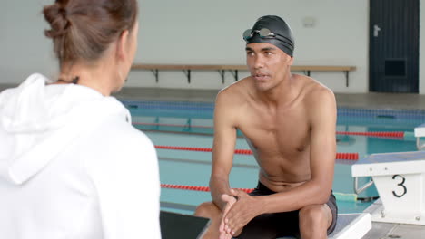 Schwimmer-Bespricht-Leistung-Mit-Trainer-Am-Beckenrand