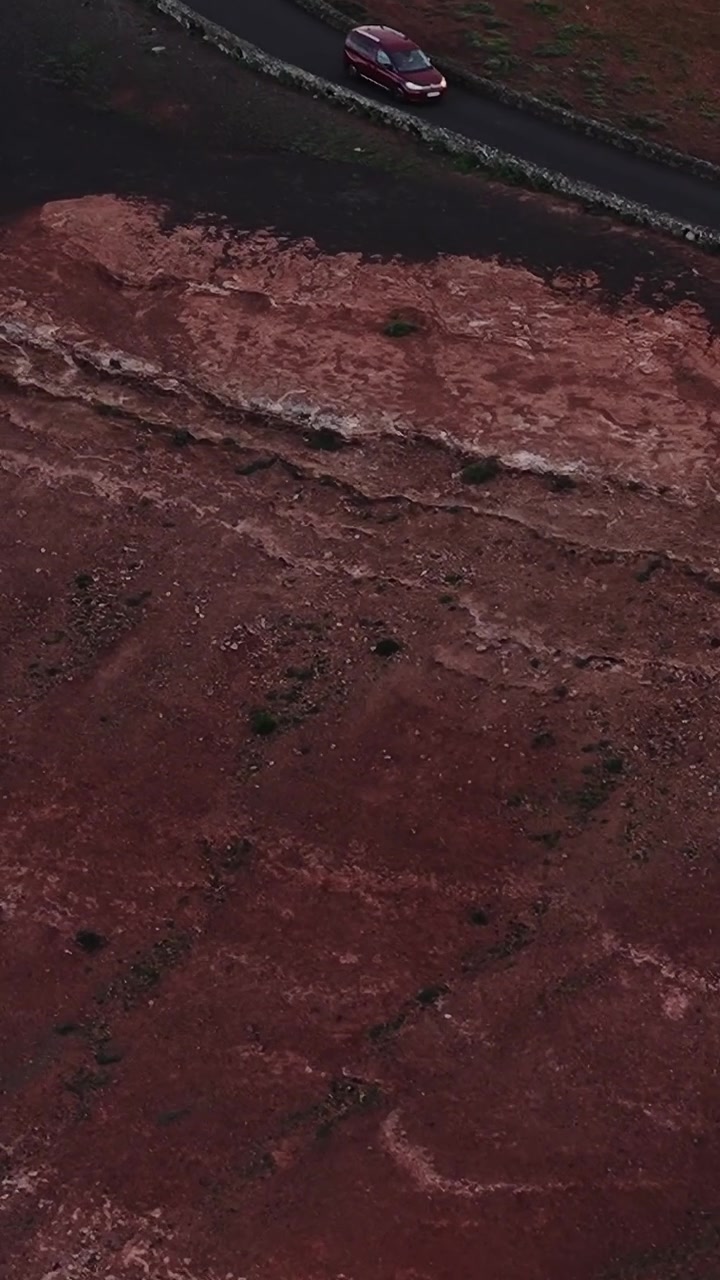 Paesaggio rosso a Lanzarote, Spagna, di giorno, vicino a una strada.