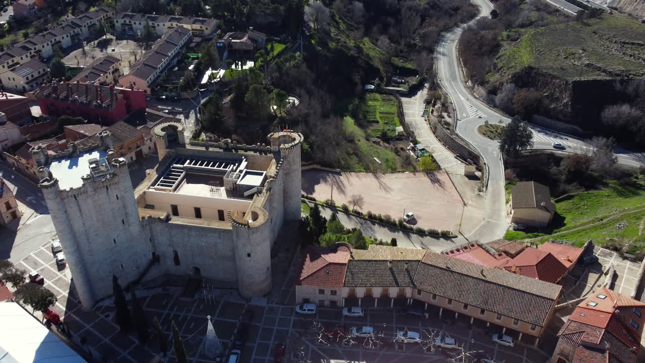Aerial view of a historic Spanish town with a castle and plaza