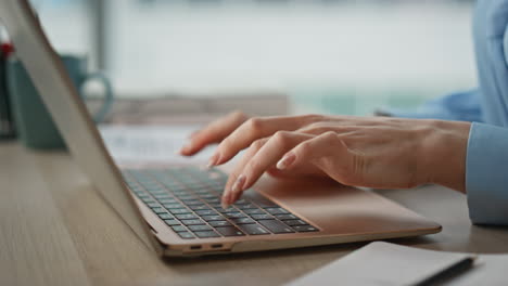 woman hand writing notebook at wooden desk closeup. unknown female freelancer