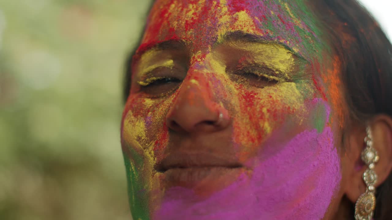 Primo piano di donne indiane con il viso imbrattato di vivaci colori Holi