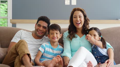 Family-sitting-on-sofa-and-watching-television