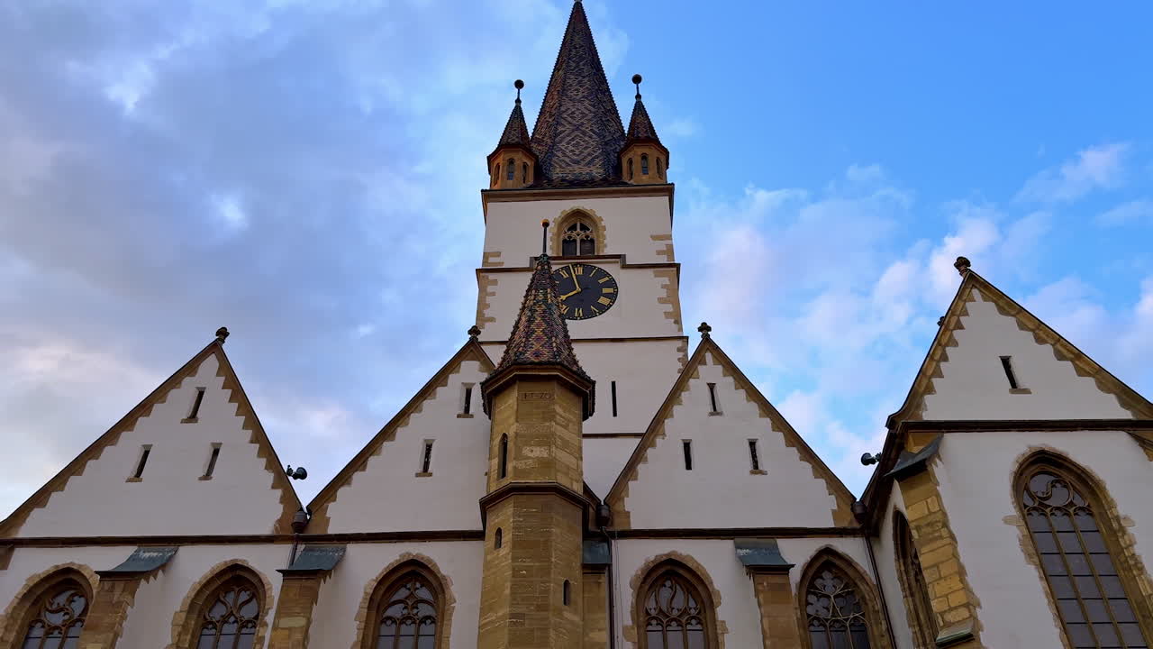 Peaceful night at Sibiu Piata Mare. Warm lights highlight baroque buildings and church tower under a starry sky