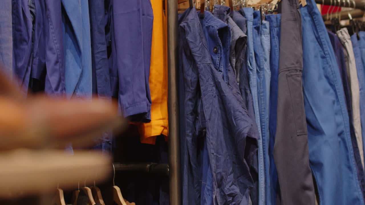 Used Clothing Hanging On The Rack With Denims In Second Hand Store