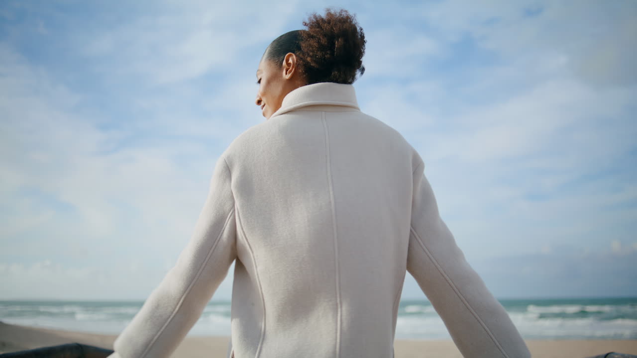 기쁜 여자가 구름이 가득한 하늘에서 바가에서 회전합니다. 행복하고 조용한 소녀가 휴식을 즐기고 있습니다.