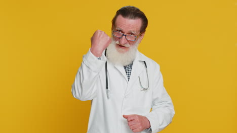 smiling doctor in a white coat posing in front of a yellow background