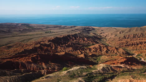 Toma-Cinematográfica-De-Un-Dron-Volando-Sobre-Las-Crestas-De-Las-Montañas-En-El-Cañón-De-Cuento-De-Hadas-Y-El-Lago-Issyk-kul-En-Karakol,-Kirguistán