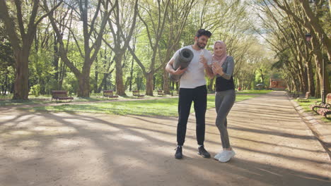 una pareja tomando una selfie en un parque después de hacer ejercicio