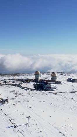 Aerial View of Snowy Mountaintop with Radar Stations and People